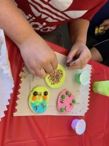 A child's hands decorating cookies. 