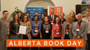 Group photograph of Alberta publishers with Minister Fir, who is holding the declaration of Alberta Book Day 2023. At the bottom of the photograph, Alberta Book Day is written in white font on an orange background.