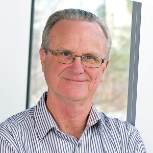Headshot of Brian Scrivener, Director of University of Calgary Press, in front of window