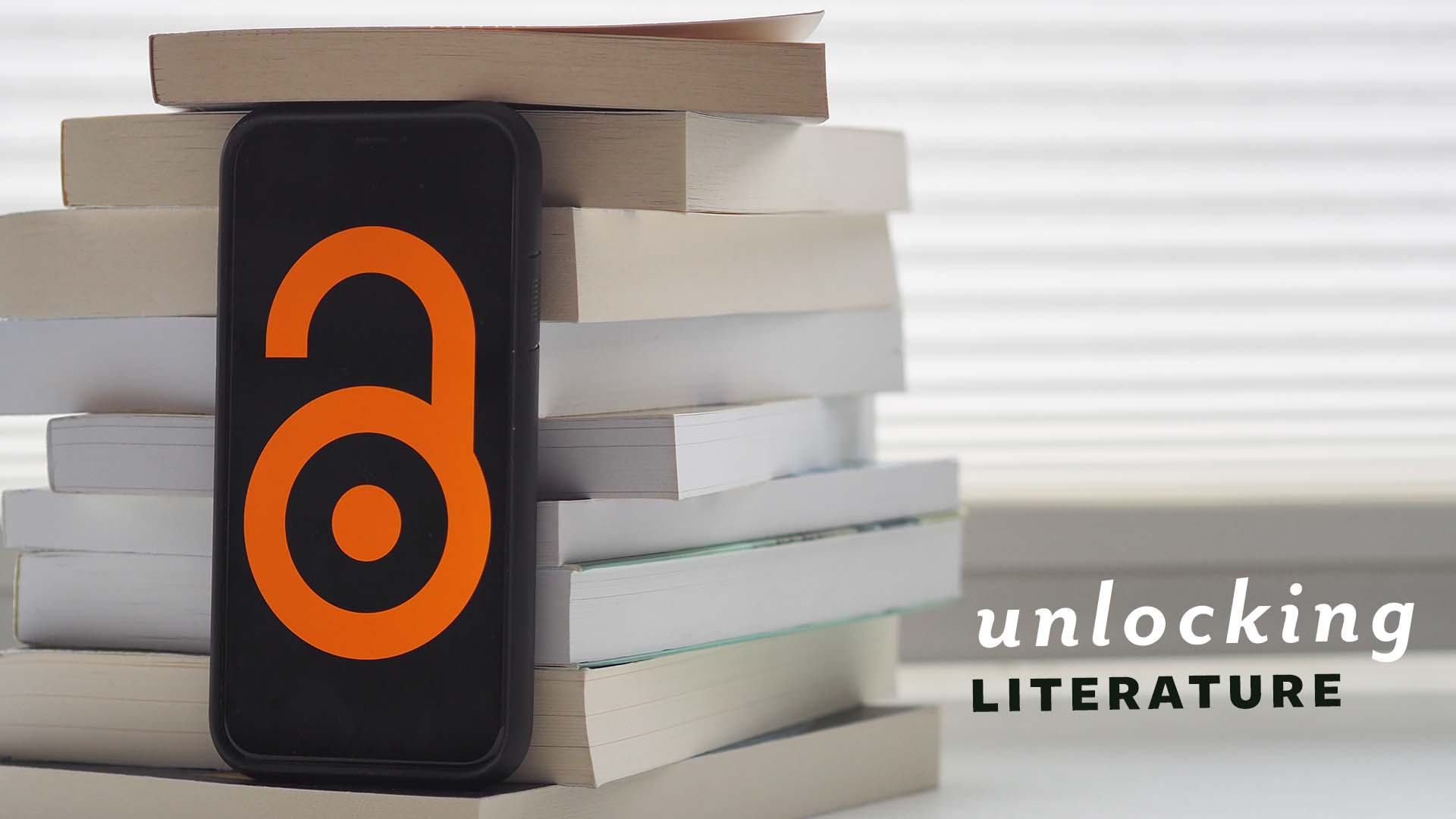 The Open Access logo (an unlocked lock) appears on a phone, which is sitting on a pile of books. The text reads "Unlocking Literature"